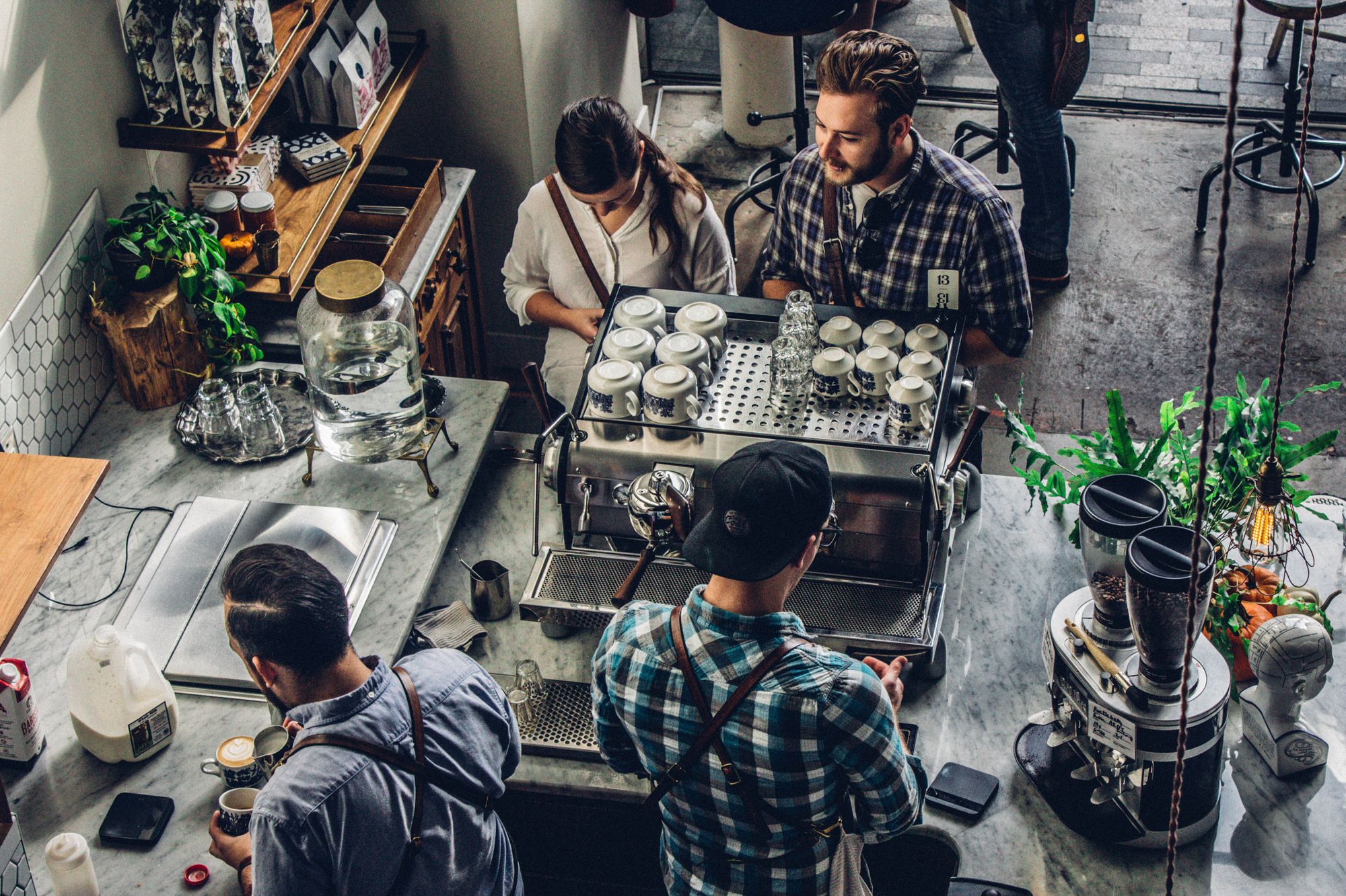 Top view of pair of customers and baristas in a coffee shop