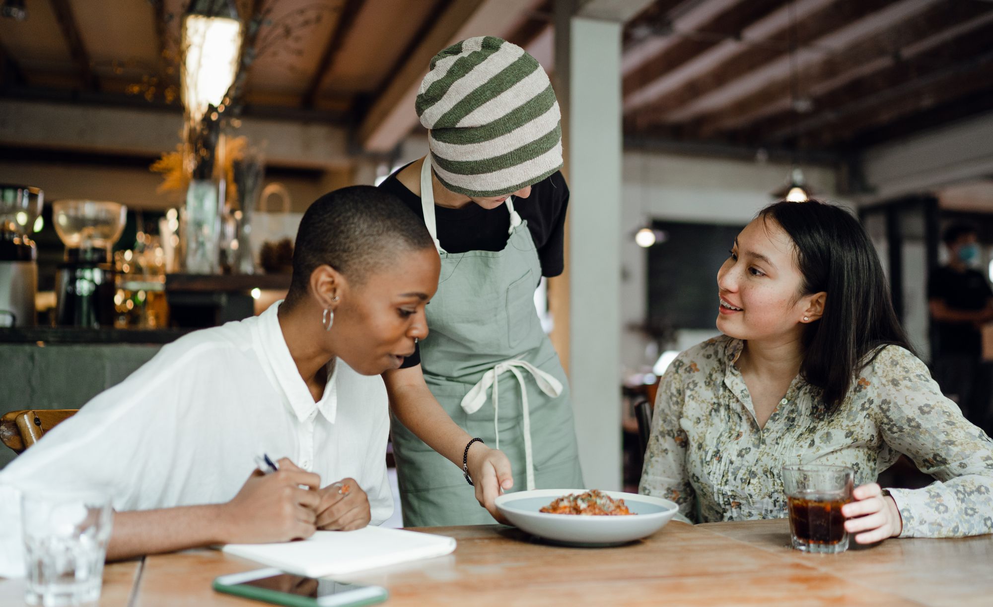 Two women in a restaurant having food served to their table